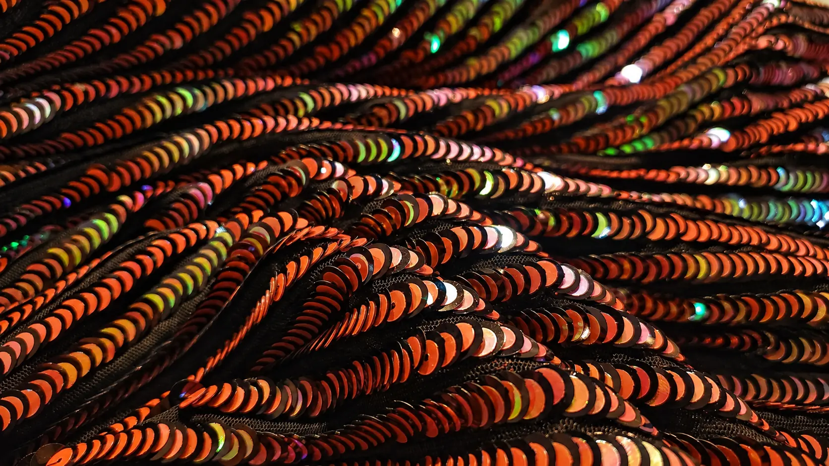 Țesătură neagră cu paiete cameleon multicolore, fotografiată în cadru larg