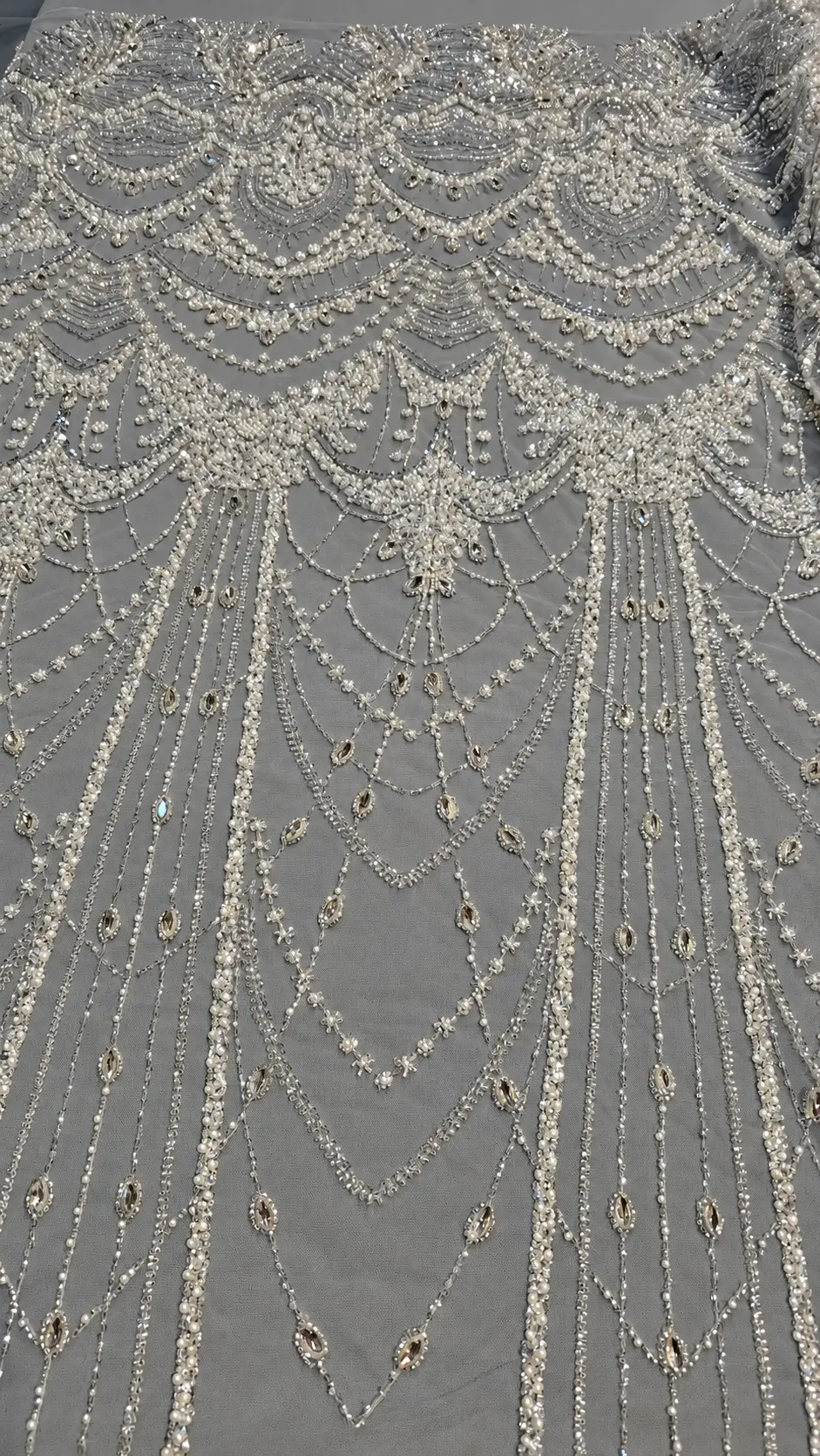 Ghirlande în cascadă, medalioane ornamentale și linii verticale pe tul gri